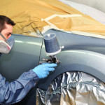Worker painting a car.